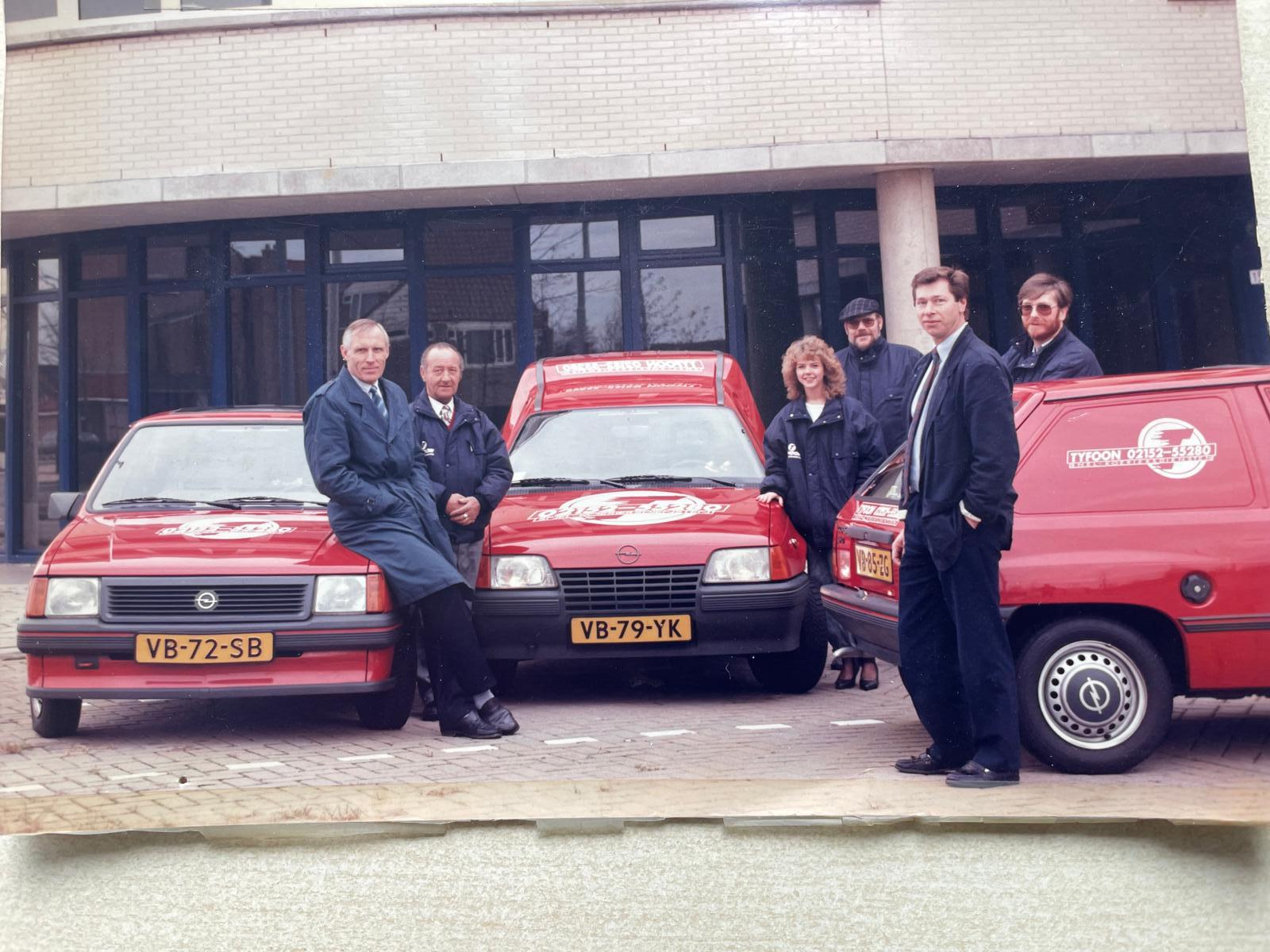 Historische foto van het TYFOON team met rode voertuigen